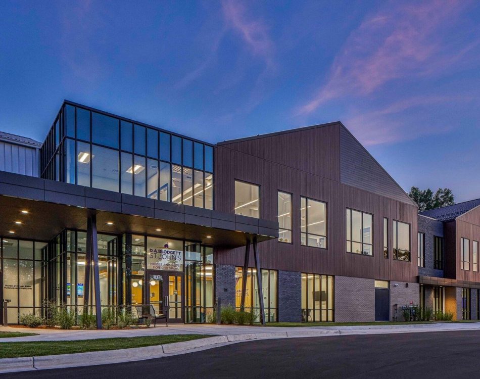 A modern building at dusk with large windows. Relevant keyword: children in need.